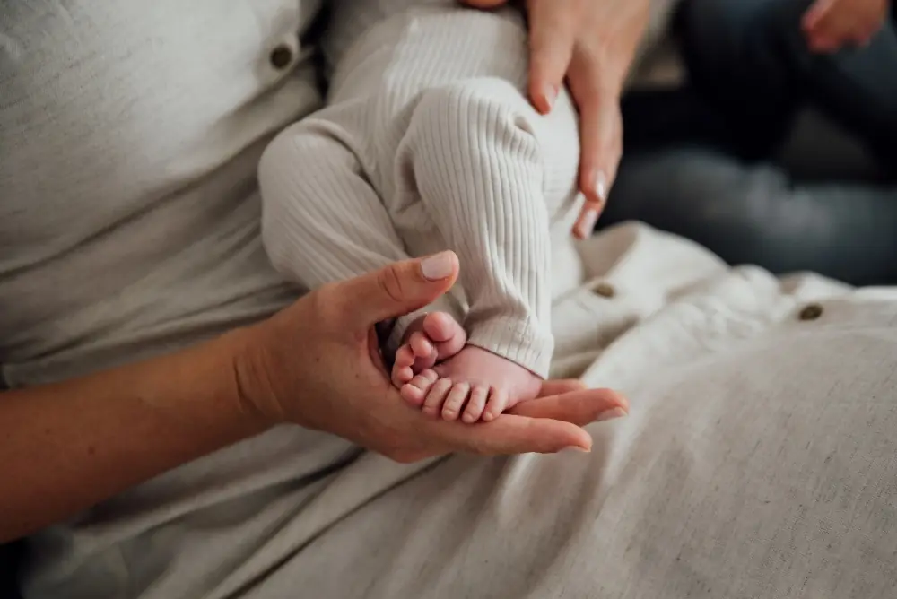 Babyfüße in den Händen der Mutter